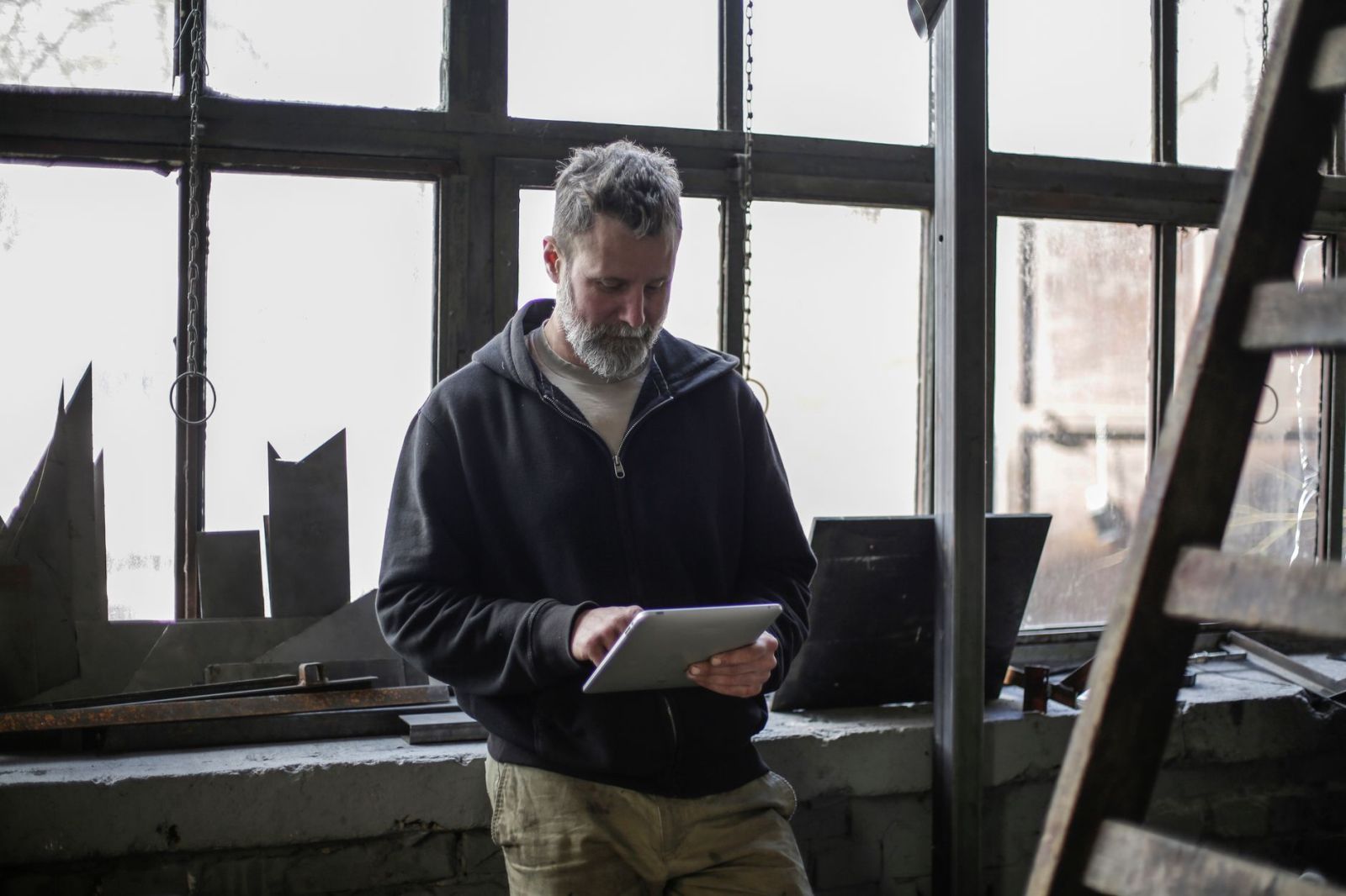 A workman checking a tablet in his workshop