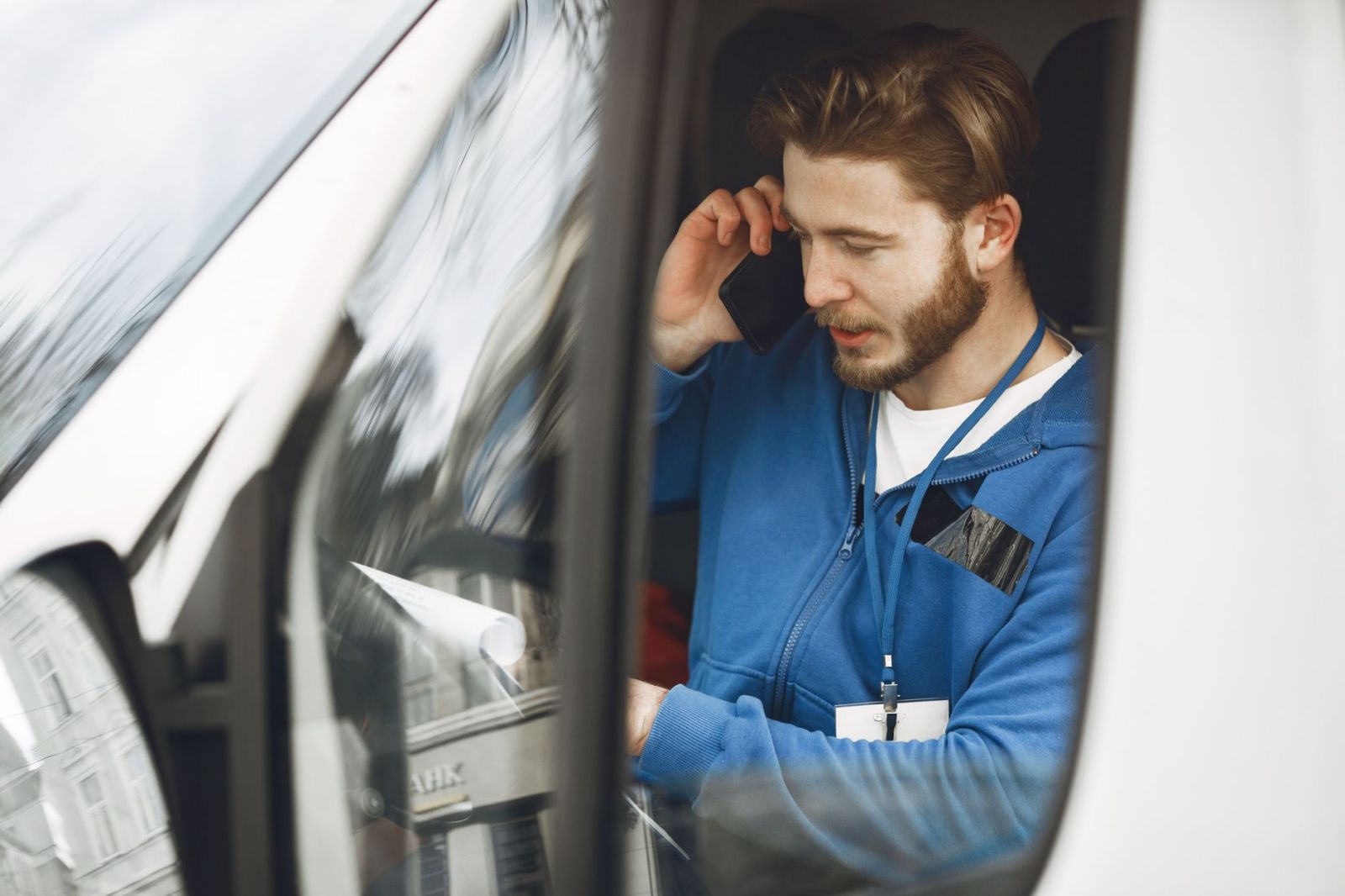 A tradesman on a phone call in his work vehicle