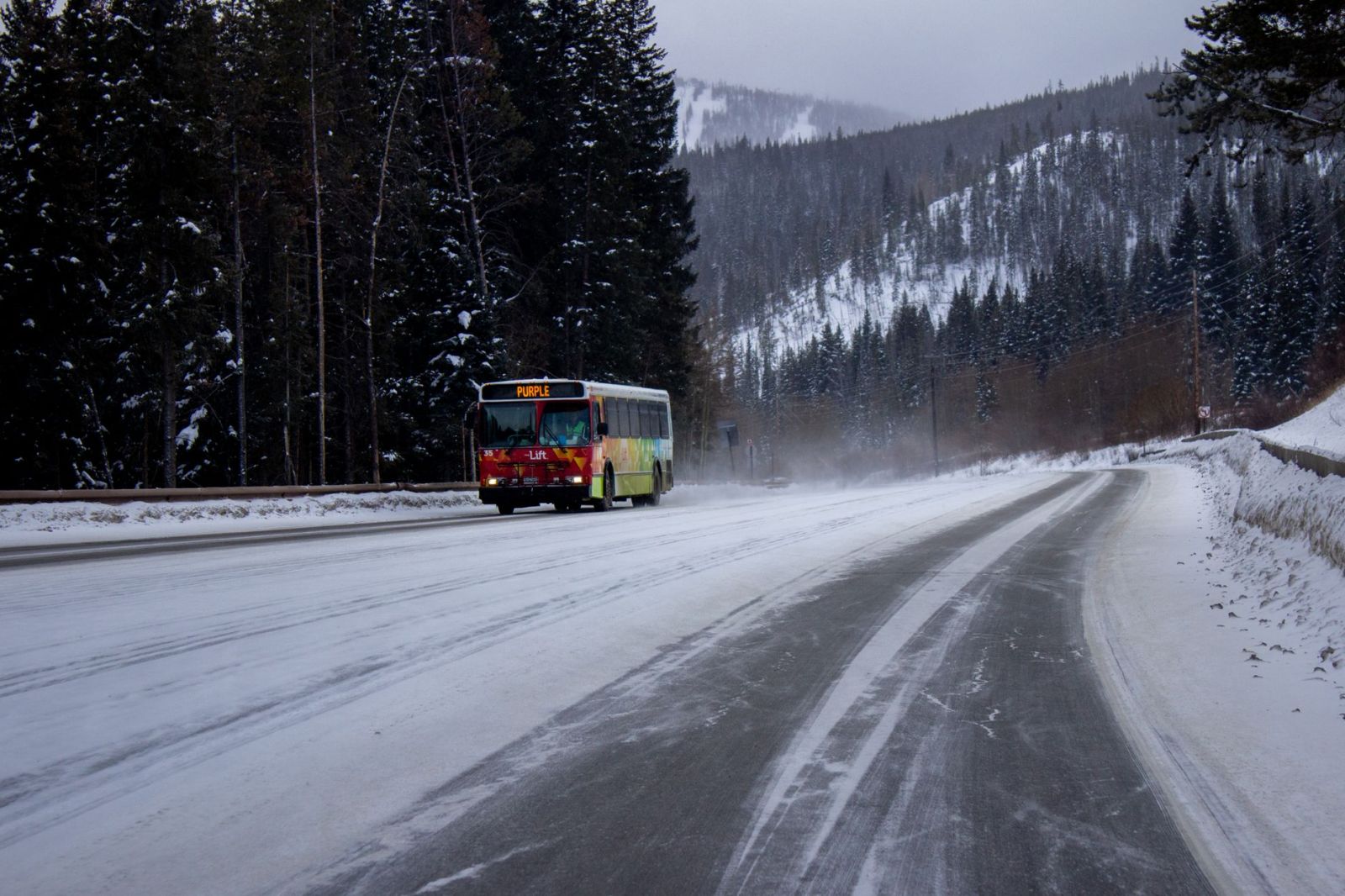 A bus on a snow-covered road in Winter Park, Colorado